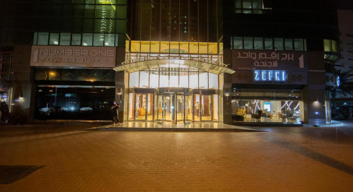 Night view of the entrance of Number One Tower Suites Dubai with illuminated lobby and restaurant signage