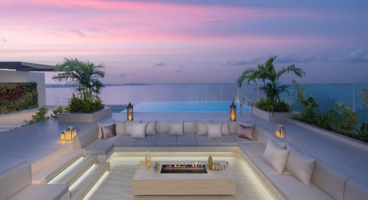 Luxury rooftop terrace at Mandarin Oriental Jumeira Dubai with private seating, fire pit, and ocean-view infinity pool at sunset