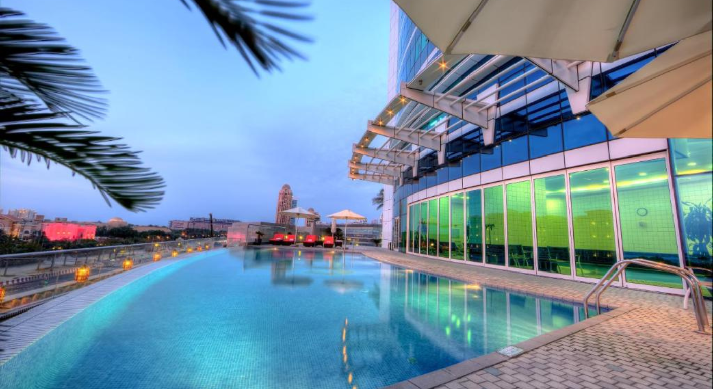 Rooftop swimming pool at Tamani Marina Hotel and Hotel Apartments in Dubai Marina with city skyline views at dusk