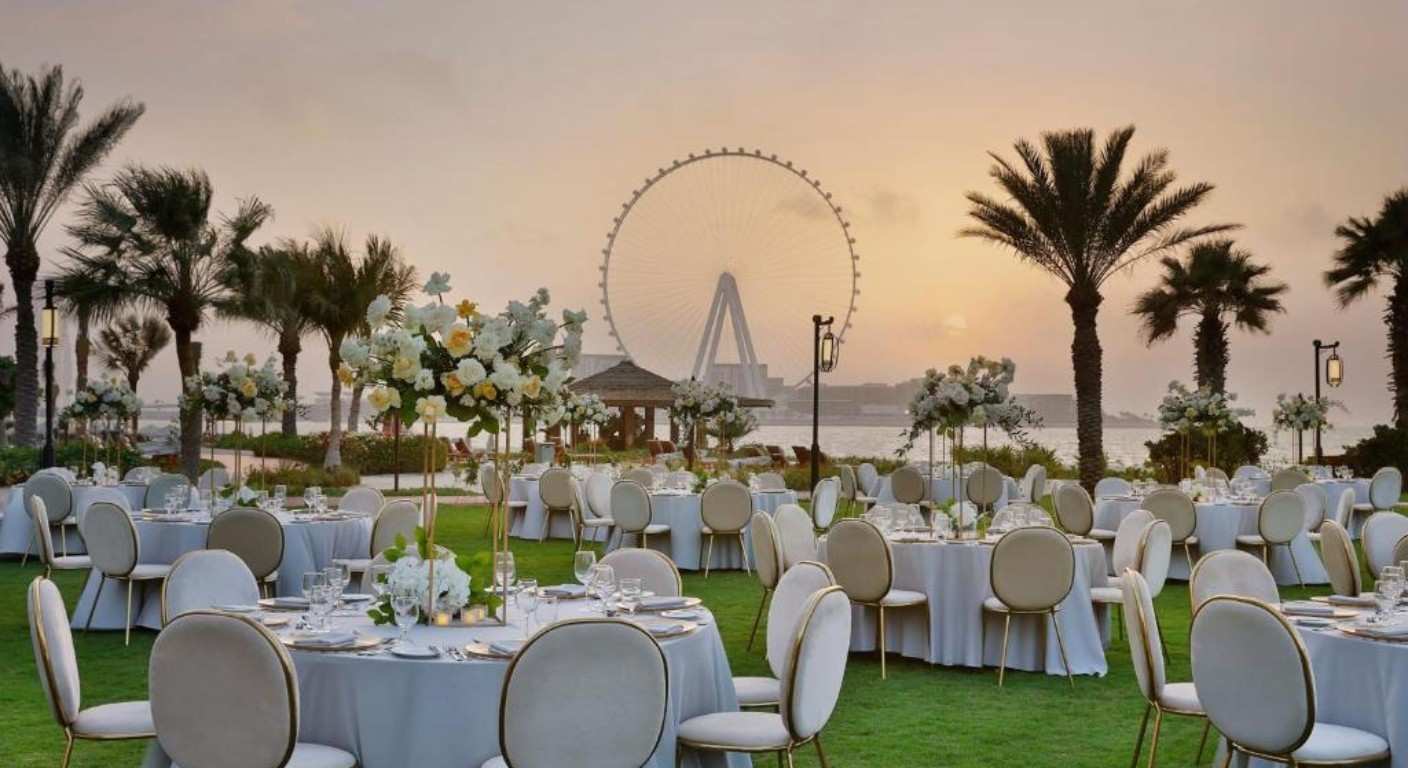 Outdoor beachfront event setup at The Ritz-Carlton Dubai with palm trees and Arabian Gulf views