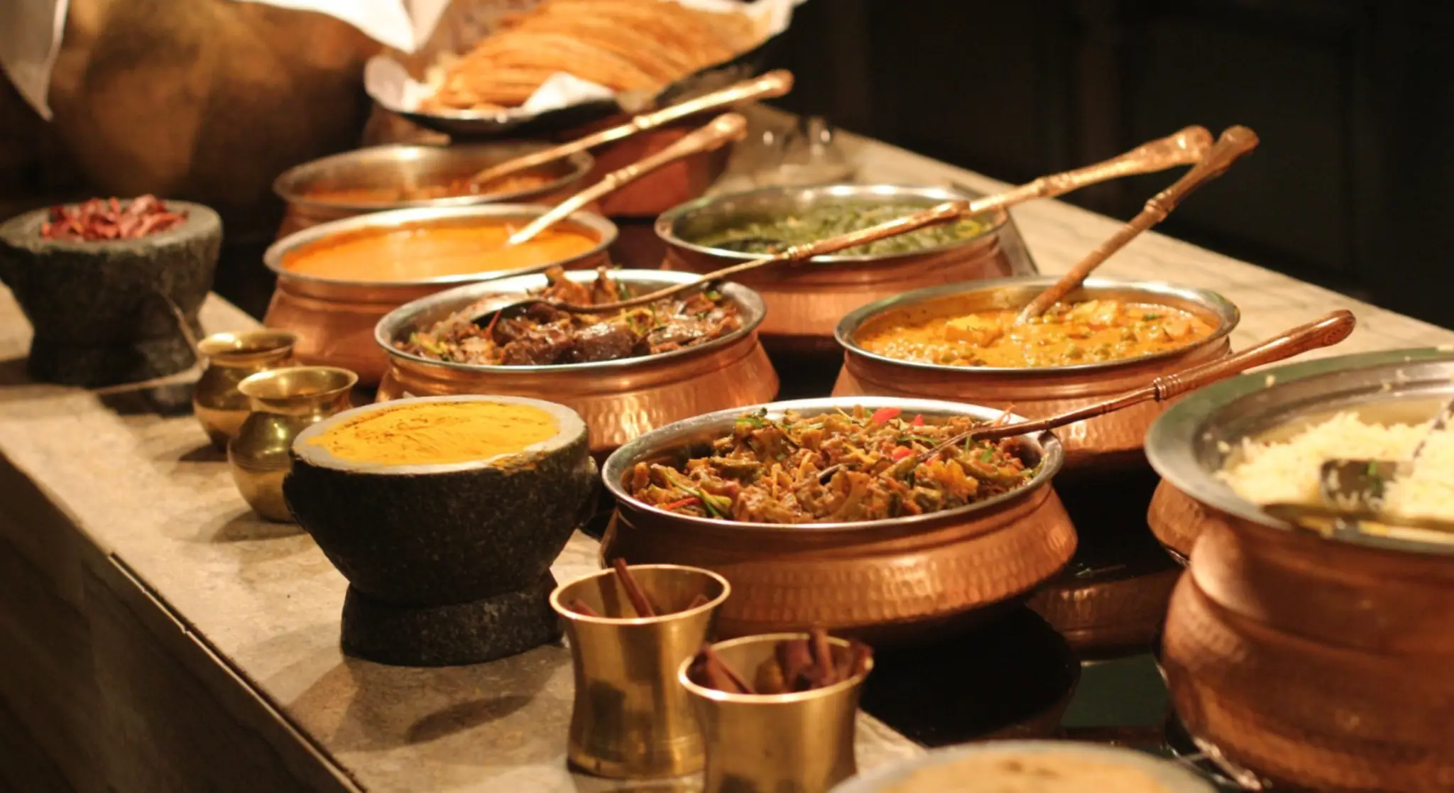 Traditional Indian curry pots and buffet setup