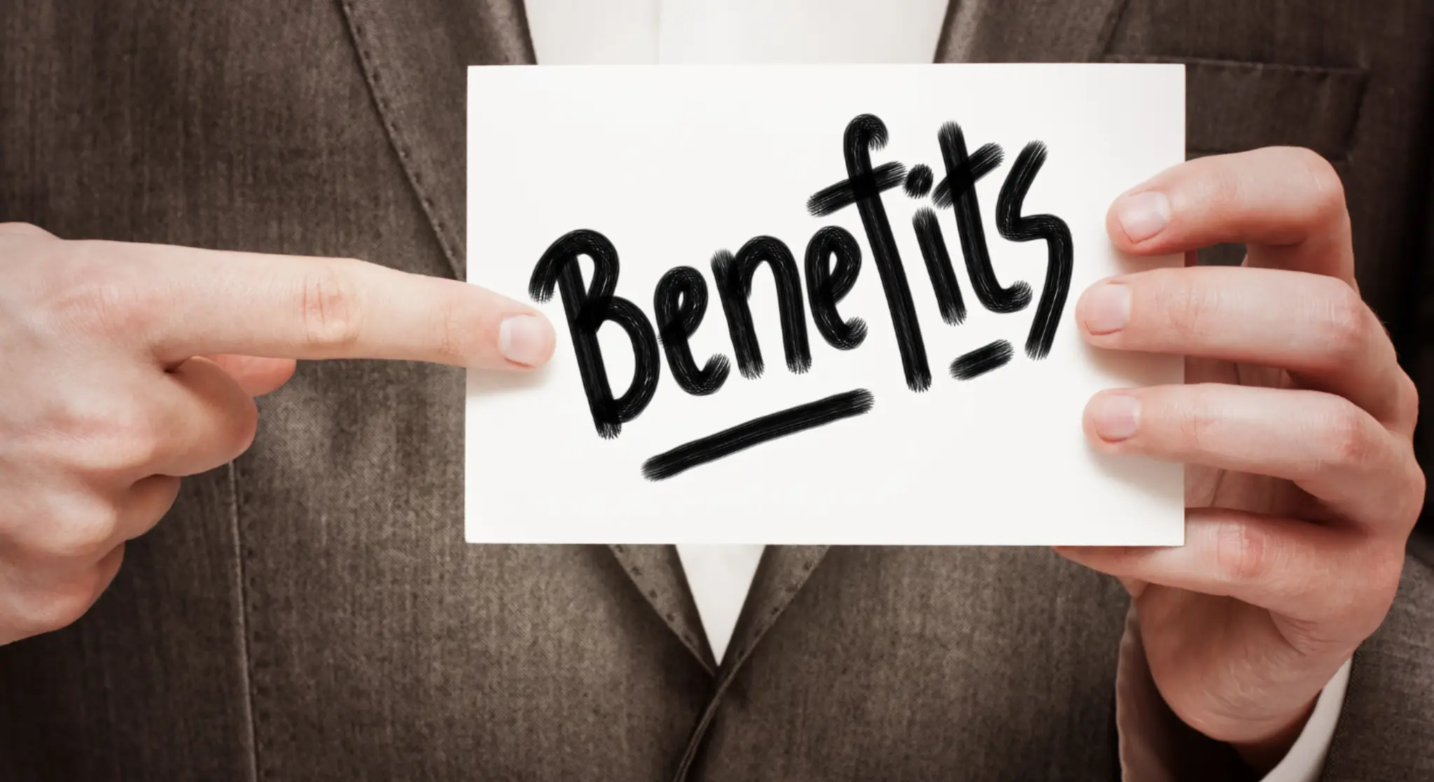 Business professional holding card with word benefits written on it — concept of advantages or travel visa benefits.