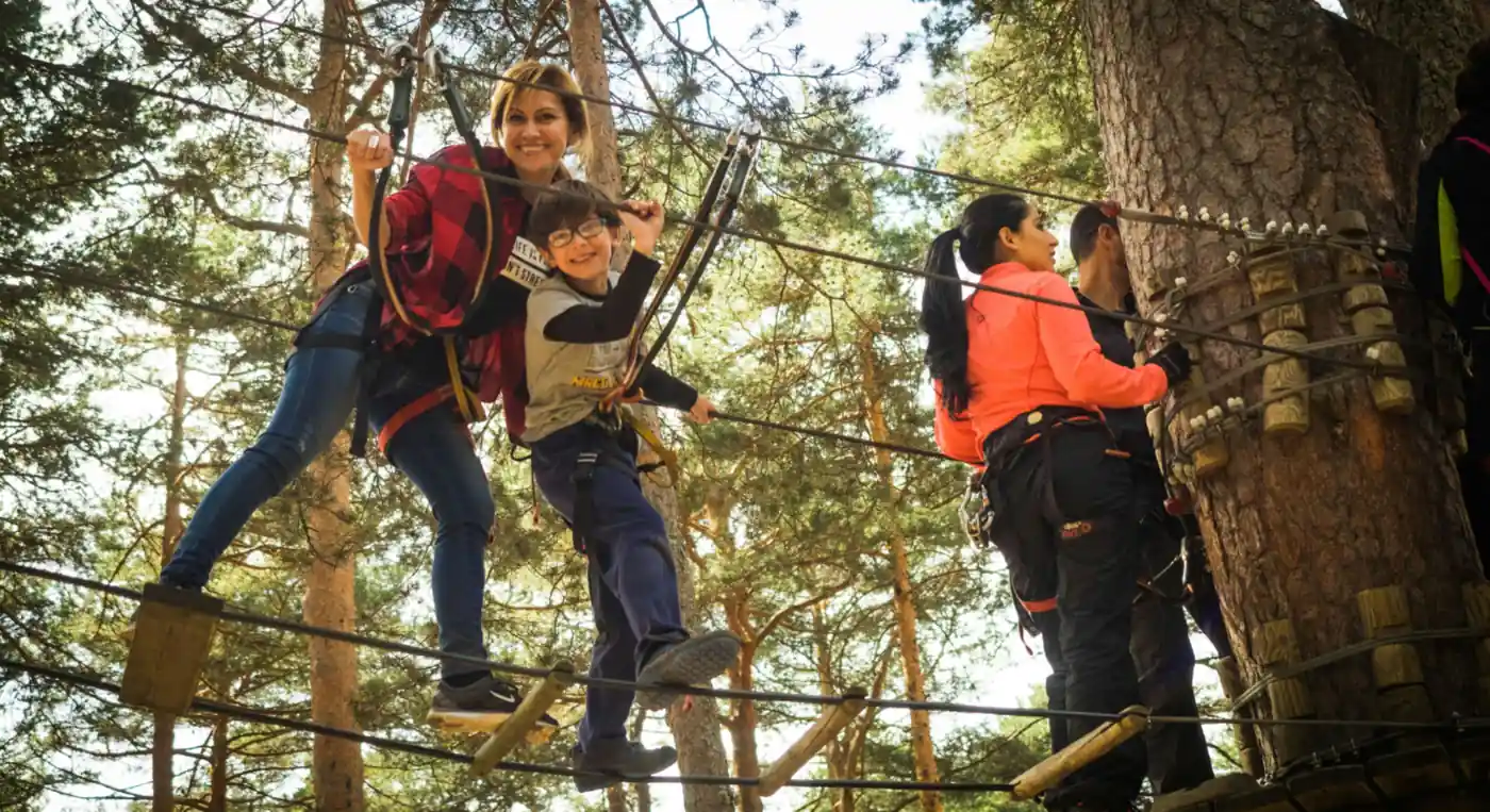 Family enjoying rope adventure park and zipline activity in forest — outdoor adventure near Jebel Jais UAE 