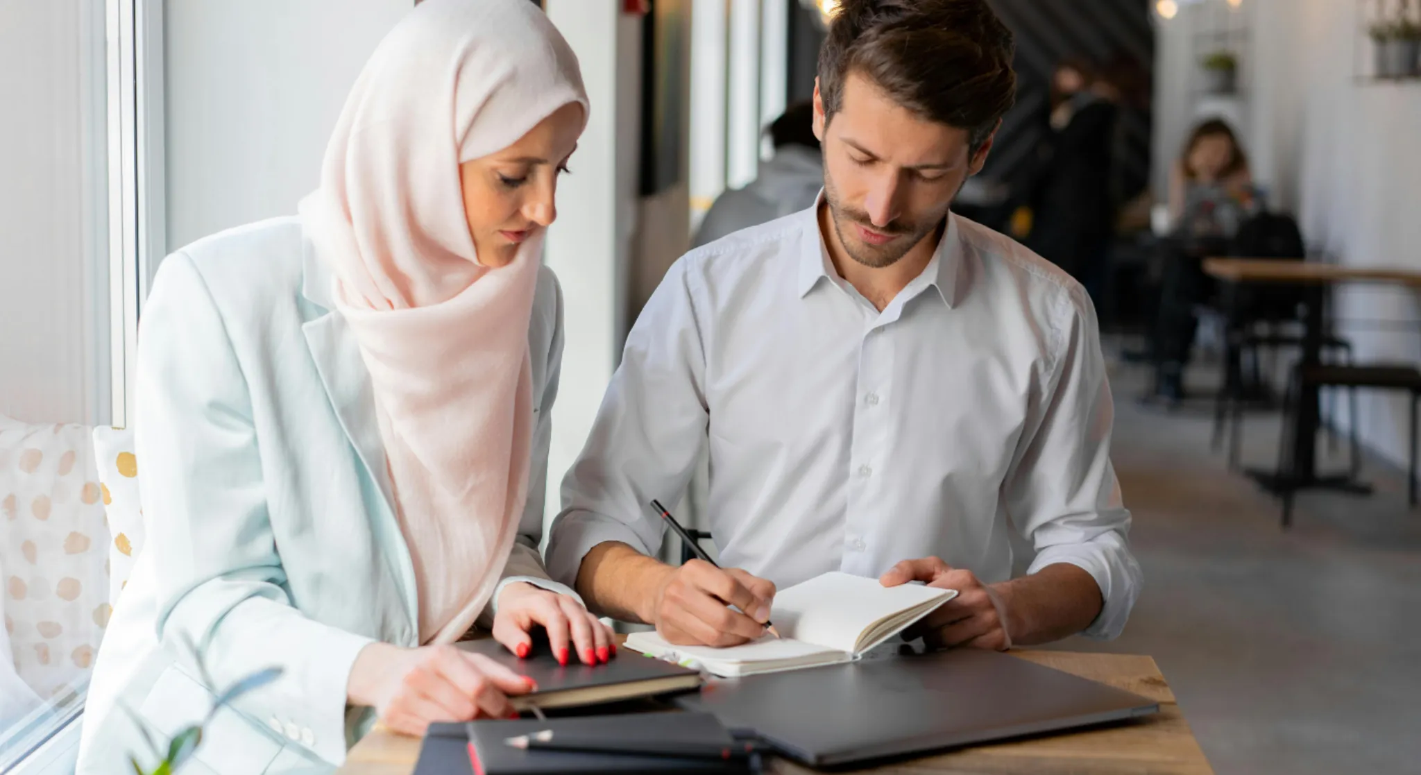 Business meeting in Dubai café with professionals discussing notes