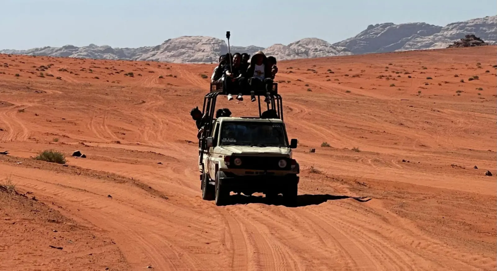 Tourists riding 4x4 jeep across desert landscape during UAE desert adventure tour