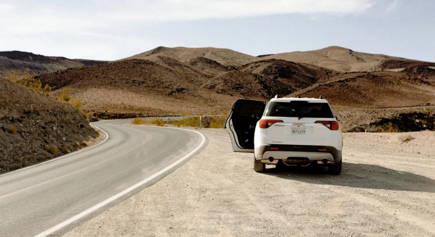 Scenic desert road drive in UAE with SUV parked near mountains