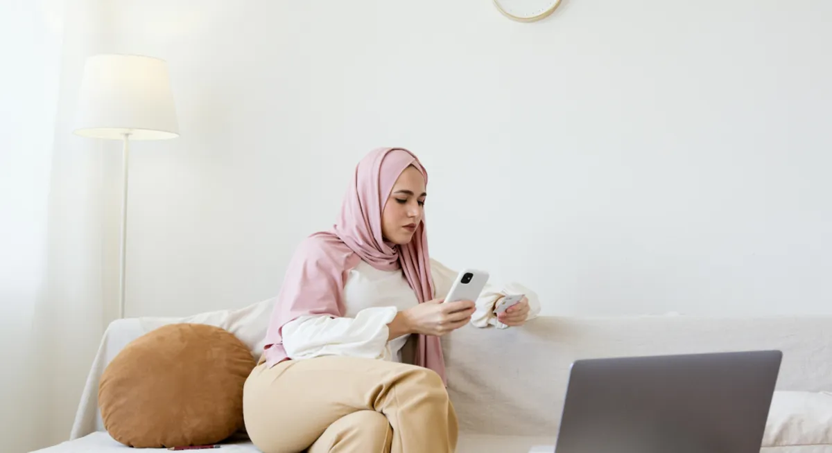 Smiling Emirati professional using laptop at workspace with copy space