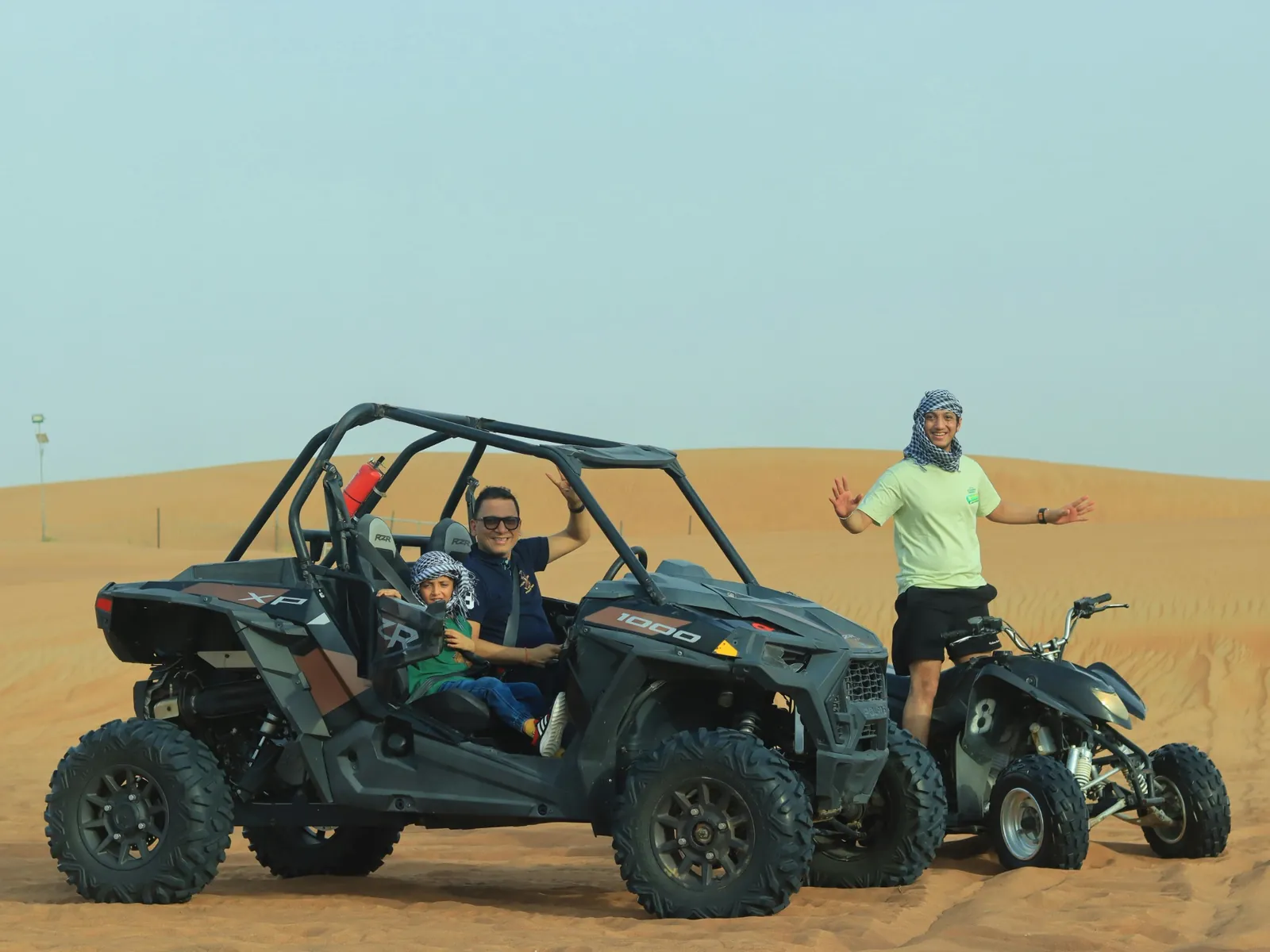 Family enjoying desert buggy ride on sand dunes.