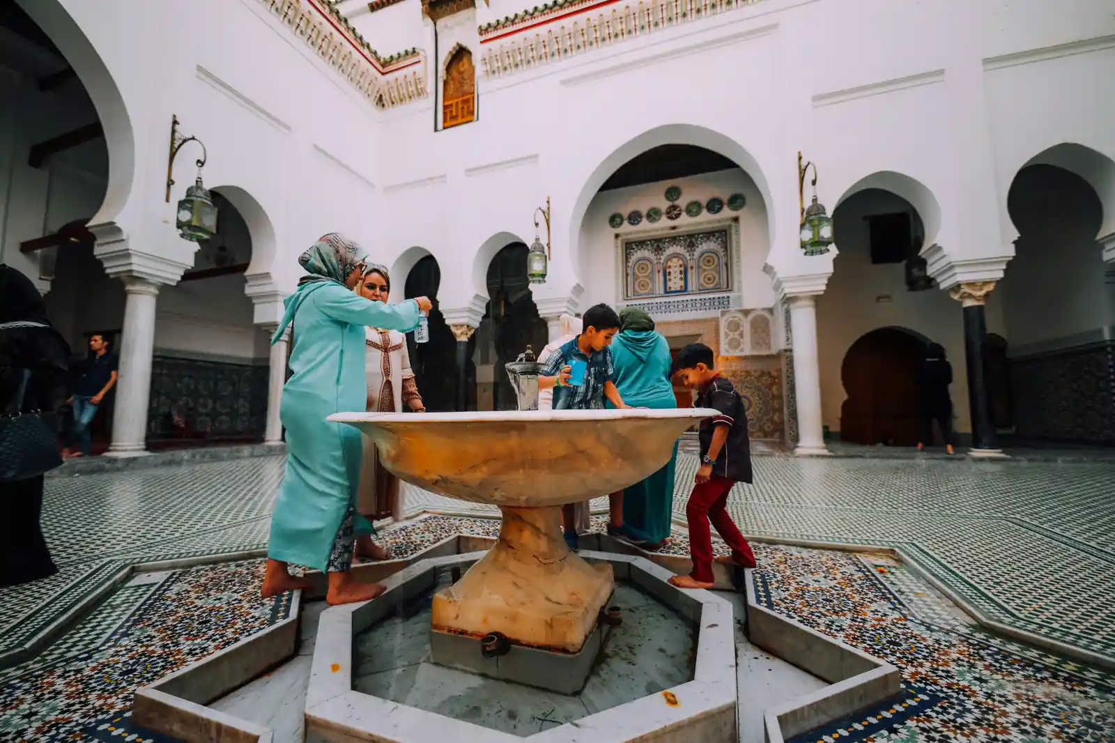 Family at traditional courtyard fountain with mosaic tiles