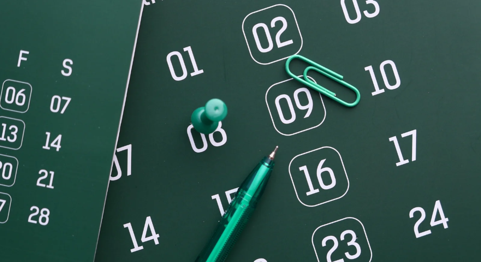 Green calendar page with dates marked and stationery items