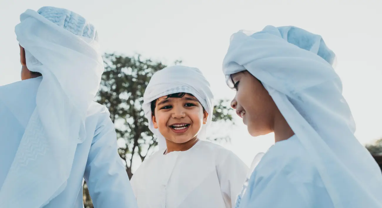 Children wearing traditional emirati clothing outdoors in uae