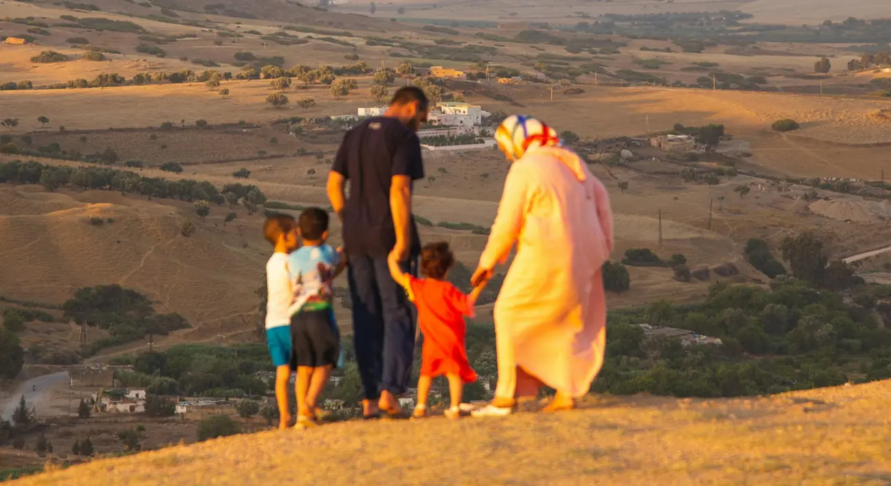 family walking together at sunset in desert landscape
