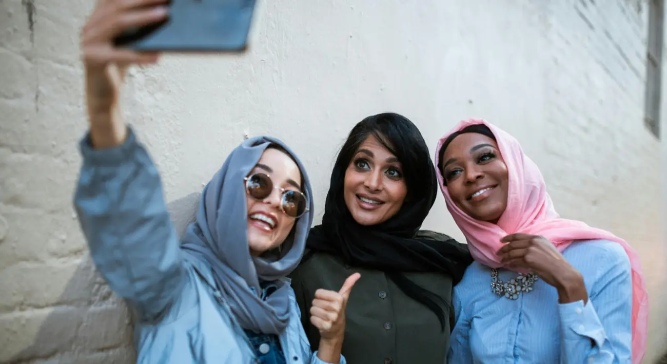 three women wearing hijab taking selfie together