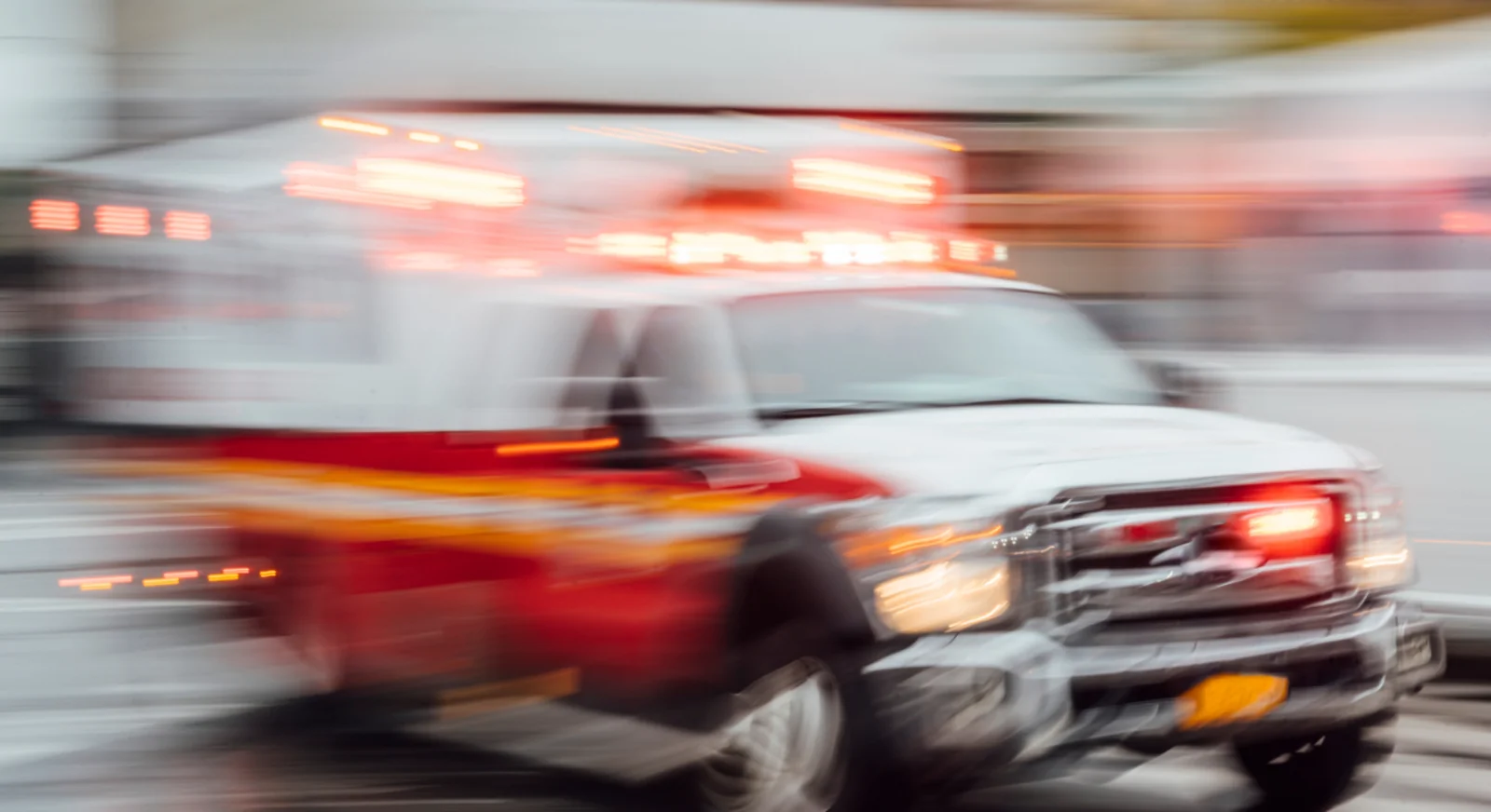 Emergency ambulance responding quickly on city street representing medical emergencies while travelling