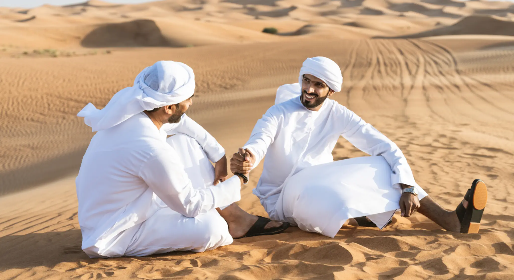Tourists relaxing on sand dunes during Abu Dhabi desert safari
