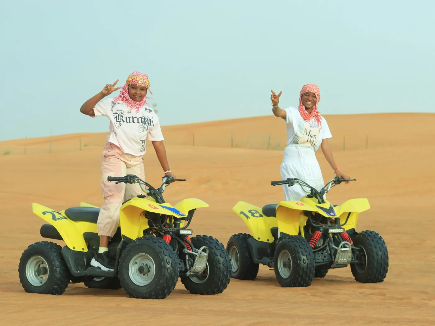 tourists riding quad bikes in dubai desert adventure sand dunes