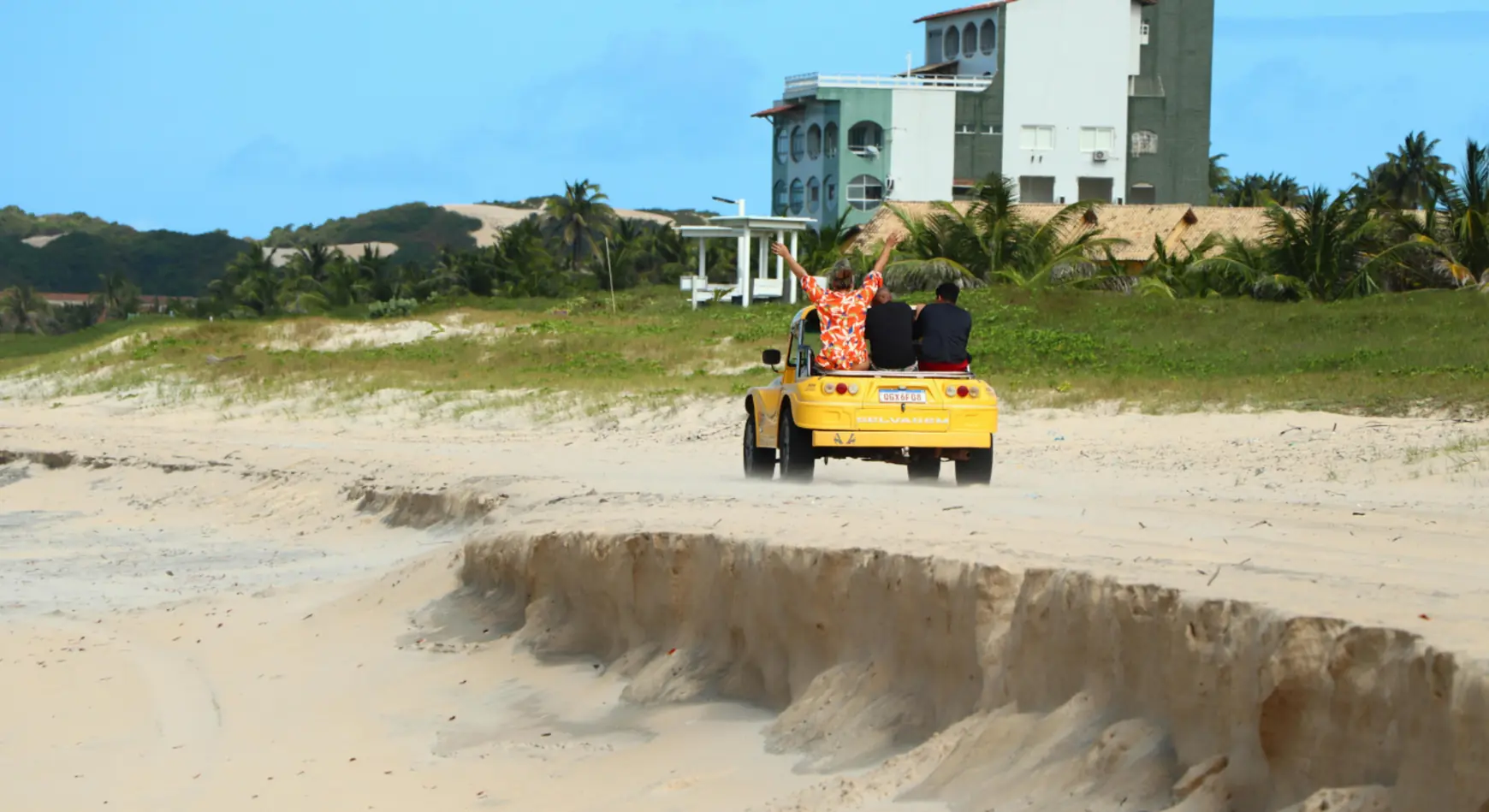 Tourists enjoying self drive dune buggy ride on sandy beach terrain