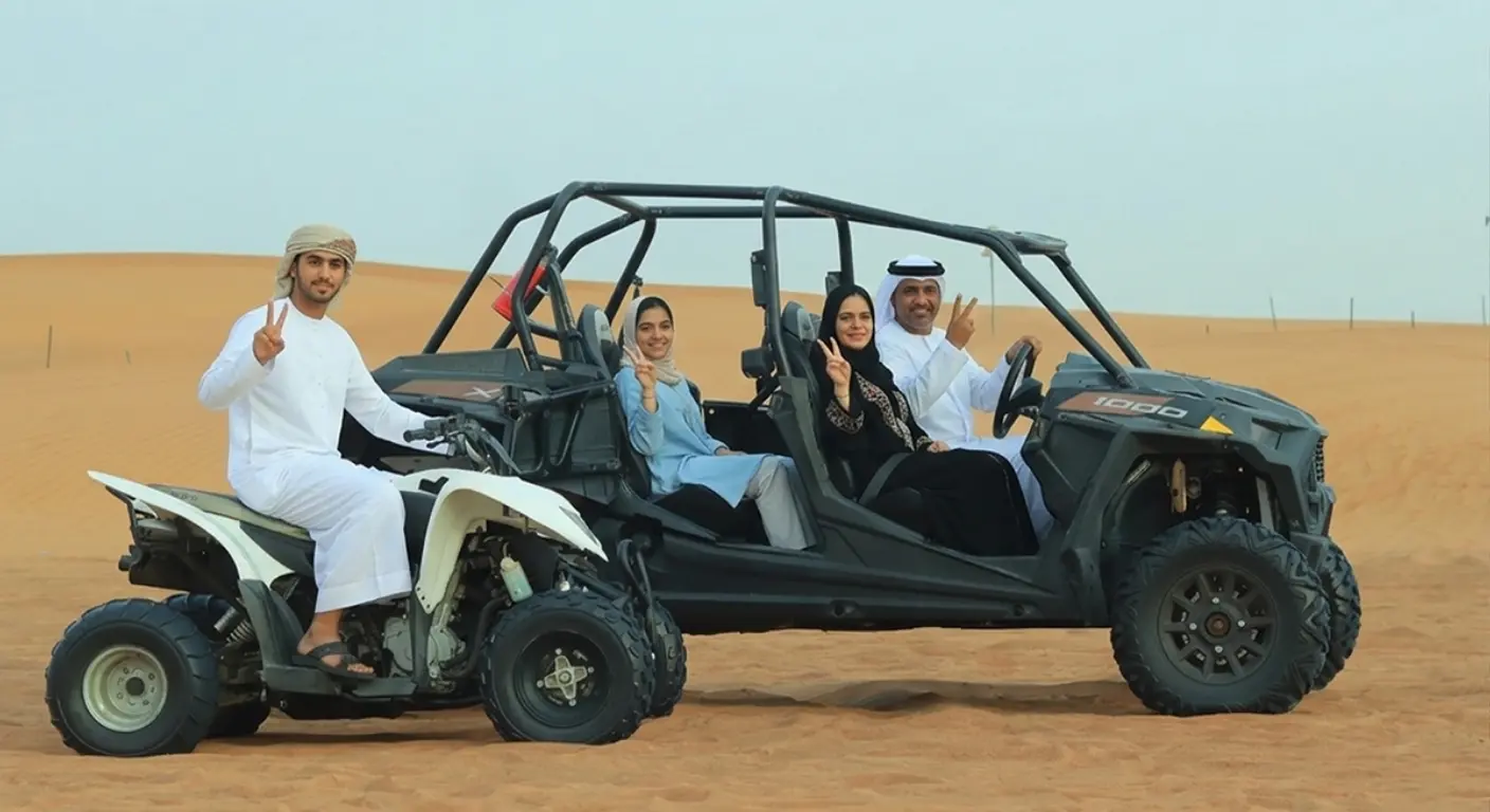 Tourists riding quad bike and dune buggy in Dubai desert with group desert safari experience