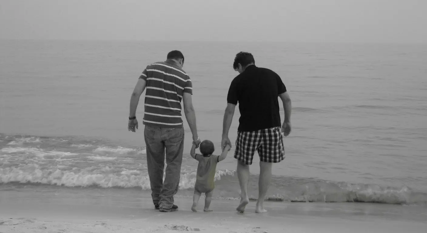 Parents walking with child on beach symbolising family bonding and travel memories