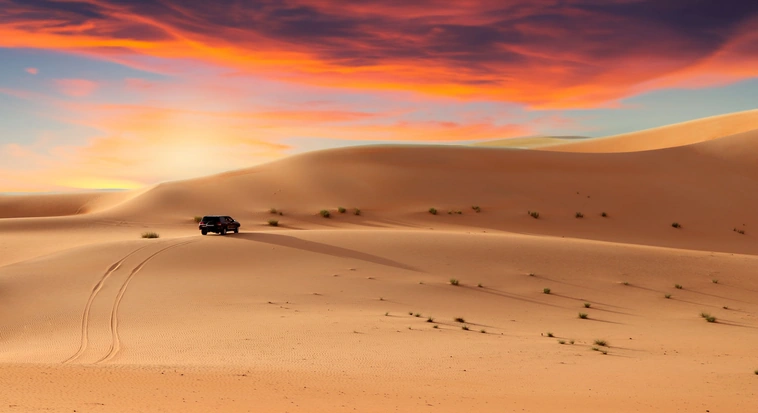 4x4 driving across the Abu Dhabi dunes at sunset