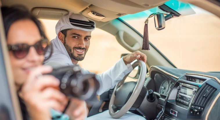 Off-road guide assisting a tourist during an Abu Dhabi desert safari