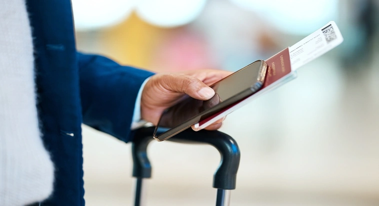Dubai visitor holding a passport, flight ticket and mobile phone while travelling