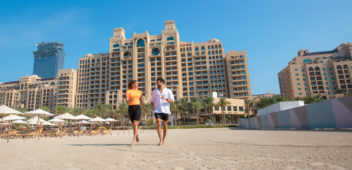 Tourists enjoying a Dubai beach holiday with luxury hotels in the background