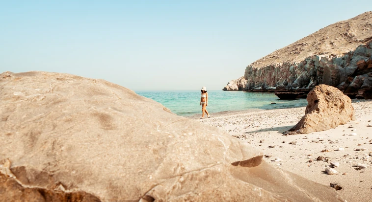Traveller exploring a rocky beach in Oman during a Dubai to Oman trip