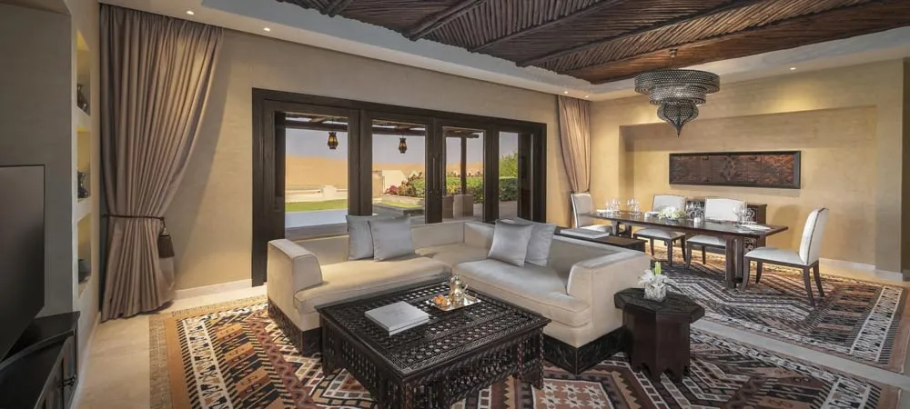 Qasr Al Sarab resort pool and palm gardens with high dunes behind