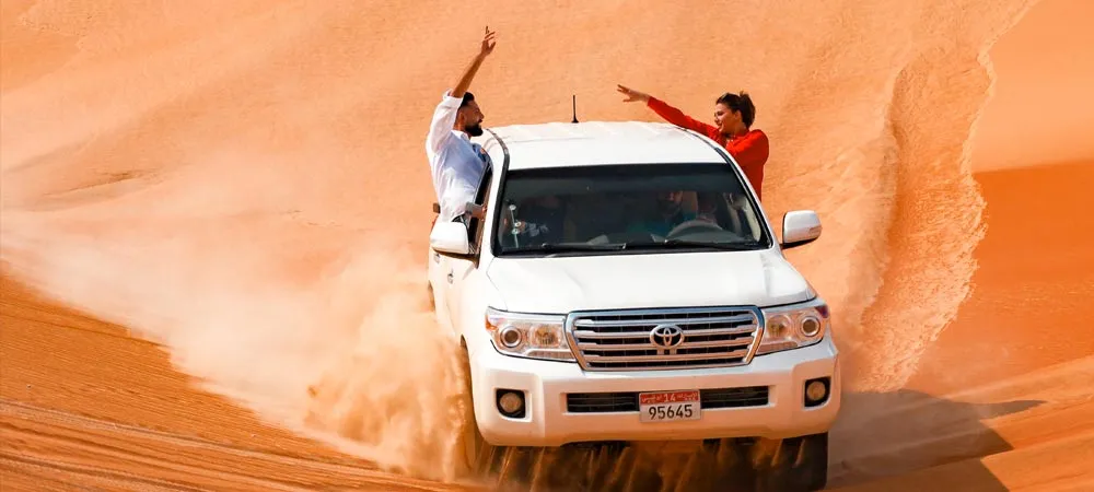 Arabiers Land Cruiser parked on a dune crest near Qasr Al Sarab at sunset