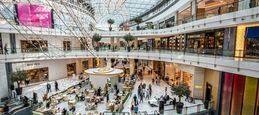 Dubai Mall interior with luxury shops, glass roof and visitors in Downtown Dubai