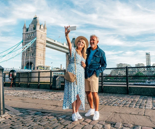 Couple taking a selfie by Tower Bridge during a London holiday from Abu Dhabi