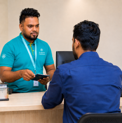 Rikas Hussain on a call at his desk at Arabiers Holidays in Colombo, booking a visa appointment and tracking an application through the visa centre