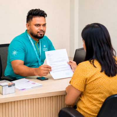Rikas Hussain, Visa & Travel Manager at Arabiers Holidays, reviewing a visa application document with a client at the Arabiers office in Colombo, Sri Lanka
